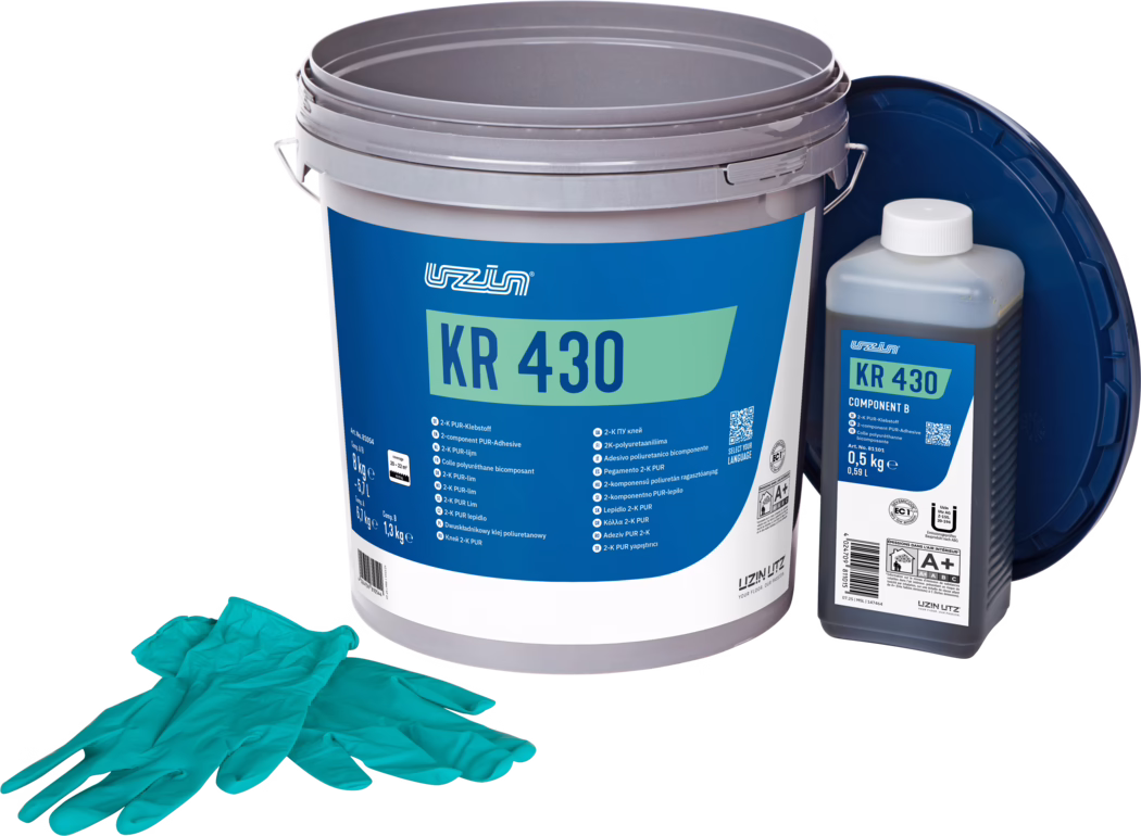 UZIN_Dummy_KR 430-8kg_2025-07 Duże szare plastikowe wiadro z etykietą 'KR 430' w kolorze niebiesko-zielonym, obok mniejsza butelka opisana 'KR 430 Component B' i para turkusowych rękawic jednorazowych; opakowanie dwuskładnikowego kleju poliuretanowego.