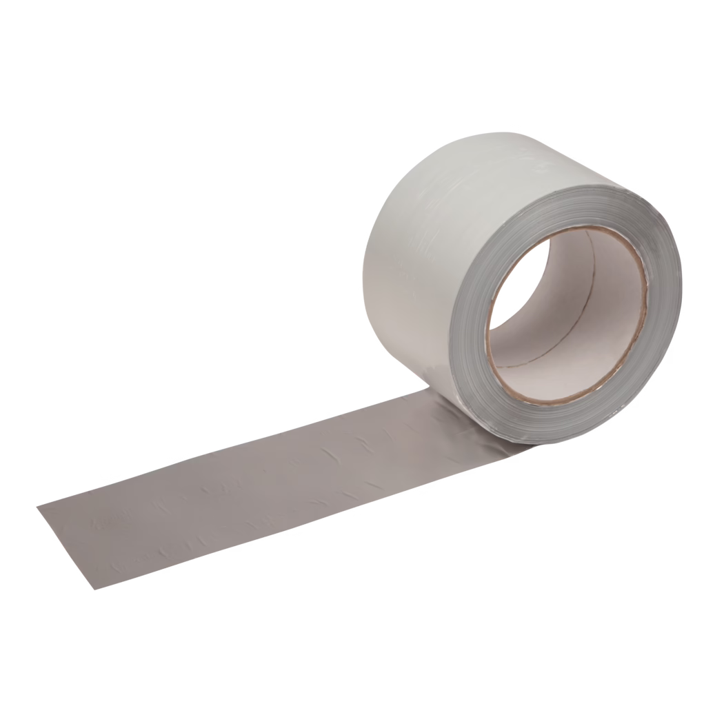 UZIN_Dummy_Alutape 75_2016-09 Zbliżenie na częściowo rozwiniętą rolkę szarej taśmy klejącej na białym tle, widoczne tekturowe rdzeń i lekko fakturowana powierzchnia taśmy.